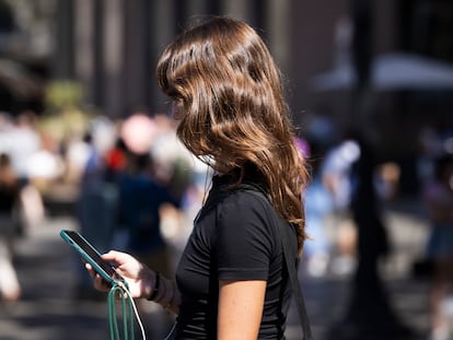 Una mujer con su móvil por el centro de Barcelona.