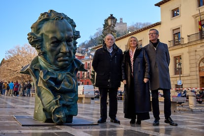 El presidente de la Academia de cine, la alcaldesa de Granada y el concejal de cultura posan junto al busto de Goya en Plaza Nueva, en Granada.