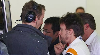 Fernando Alonso, conversa con sus mecánicos en el box.
