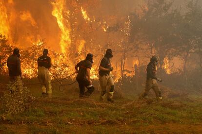 Operaris dels serveis d'extinció d'incendis treballen a la zona de Zamanes, Vigo. Les altes temperatures i els forts vents han magnificat l'efecte dels incendis a les Ries Baixes, que aquests dies tenen unes temperatures més pròpies de l'estiu.