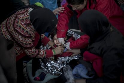 Una niña refugiada siria es atendida por su familia y una sanitario voluntaria en el campamento de Platanos, después de llegar desvanecida en la barca con la que ella, su familia y unas 40 personas más cruzaron el mar Egeo desde Turquía (Lesbos, Grecia, diciembre de 2015).