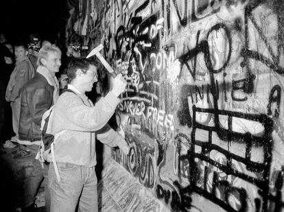 Un hombre con un martillo cerca de la puerta de Branderburgo después de que se abriera el muro. Imagen tomada el 9 de noviembre de 1989.