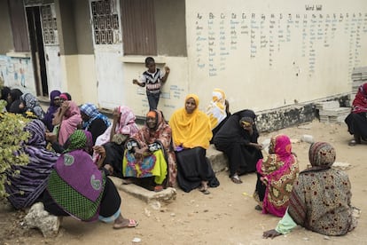 Un grupo de mujeres espera delante del colegio de Bububu, en las afueras de Stonwtown, Zanzíbar. El día 15 de cada mes, una de las aulas se transforma en un punto de pago de pensiones en el que los mayores pueden cobrar la prestación de 20.000 chelines tanzanos (unos ocho euros). Actualmente, el Gobierno de Zanzíbar, una región autónoma de Tanzania, ensaya un proyecto piloto para implementar un plan de pensiones universal para los ciudadanos de la tercera edad. Es el primer programa de África oriental financiado íntegramente por el Estado.