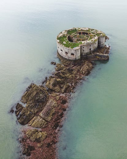 Stack Rock Fort (Gales, Reino Unido). La foto muestra una batería defensiva de piedra maciza situada en una isla rocosa cerca de Milford Haven, en Pembrokeshire. Como apunta el fotógrafo, Matt Emmett, se construyó en dos etapas. La primera estructura era un fuerte de tipo Martello —de los que se alzaron en el Imperio Británico durante el siglo XIX— emplazado en la boca de la ensenada que conduce al estratégico puerto de Pembroke Dock. A partir de 1859, y al calor del creciente temor a una invasión francesa, se reforzaron las defensas costeras de Gran Bretaña, y el fuerte de Stack Rock se transformó en la estructura circular y de mayor tamaño que es hoy. Sus habitaciones para 154 soldados y sus 54 cañones pesados, protegidos por grandes casamatas y troneras de granito, nunca llegaron a utilizarse en una guerra. Actualmente es una ruina aislada, tranquila y reconquistada poco a poco por la naturaleza. En 2021 pasó a manos del colectivo Anoniiem, que ha invitado a fotógrafos a investigar el lugar. En un futuro planea abrirlo a amantes de la exploración urbana.