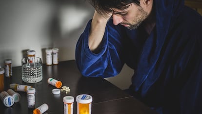 Un hombre, junto a varios botes de pastillas.