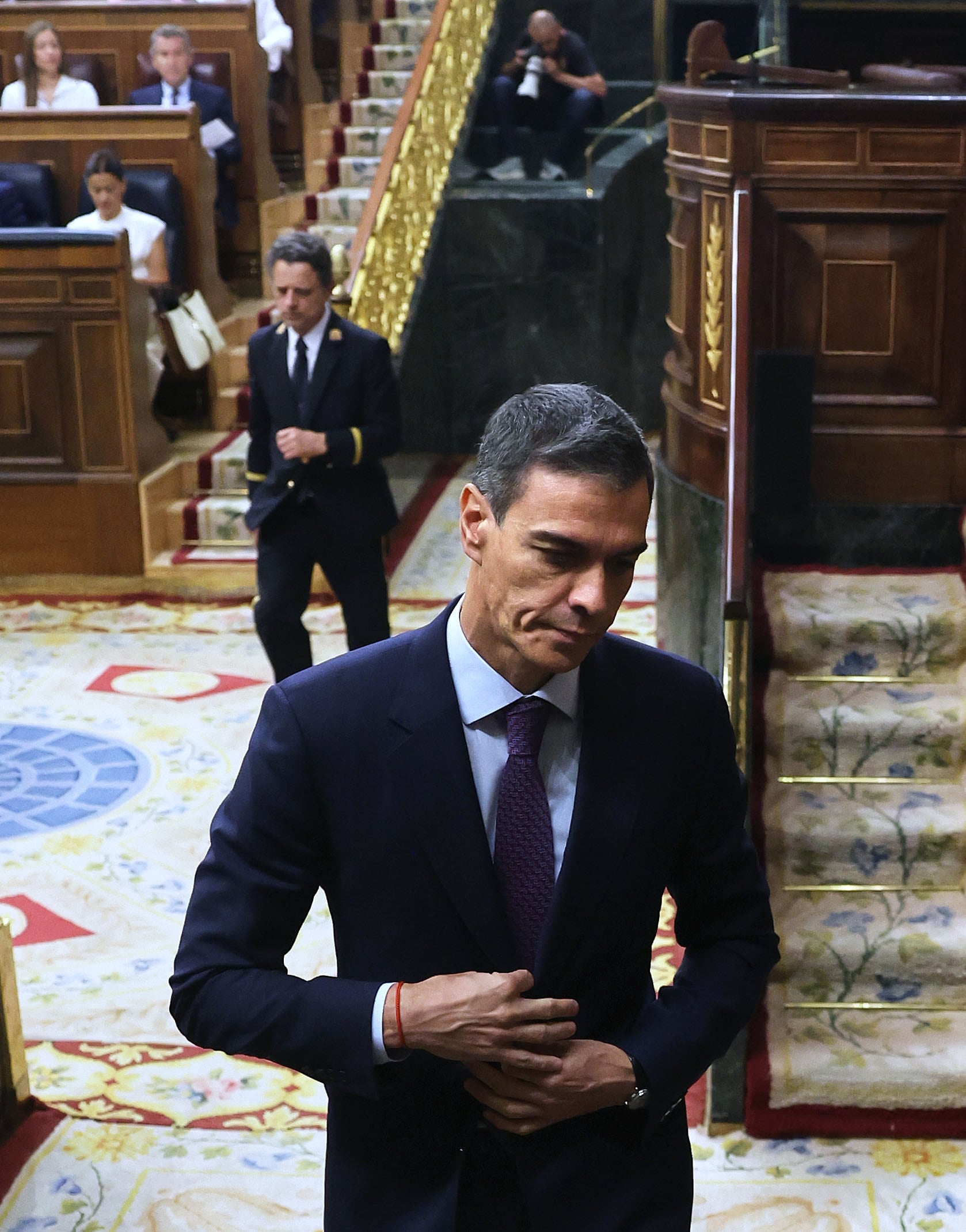 El presidente del Gobierno, Pedro Sánchez, sale del hemiciclo. Al fondo, el líder del PP, Alberto Núñez Feijóo.