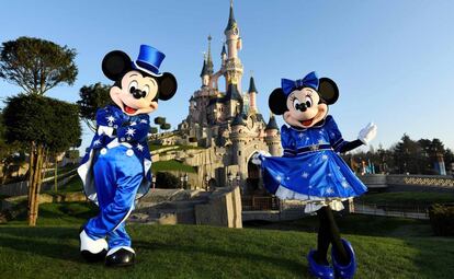 Mickey y Minnie posan frente al castillo.