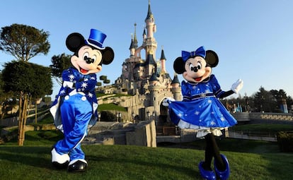 Mickey y Minnie posan frente al castillo.