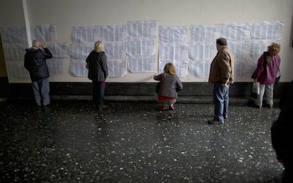 Personas buscan sus nombres en las listas de votación durante las elecciones primarias abiertas para candidatos a la Presidencia en Buenos Aires, Argentina.