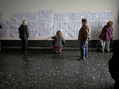 Personas buscan sus nombres en las listas de votación en las elecciones primaria en Argentina, en noviembre de 2021.
