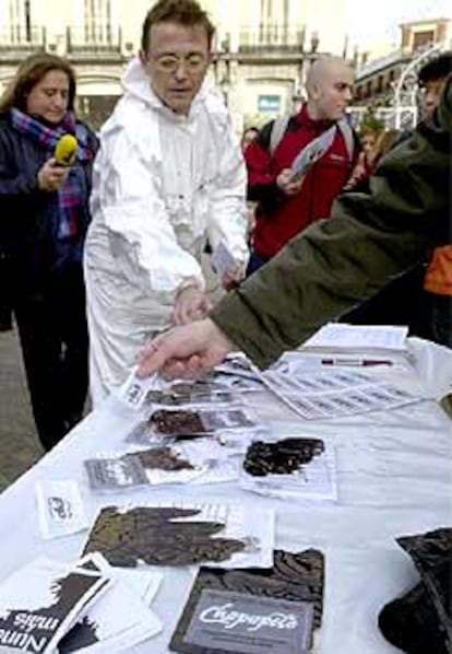 La Plataforma Nunca Máis ha entregado bolsas de chapapote tras una concentración en Madrid.