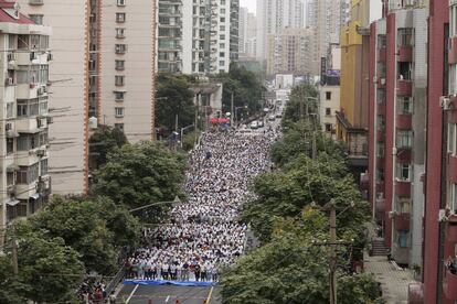 Miles de personas asisten hoy a la oración en una calle cercana a una mezquita en Shanghai.