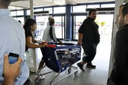 Fotografa facilitada por el SAT. Jornaleros sacan de un centro comercial diez carros llenos de material escolar. EFE/Archivo