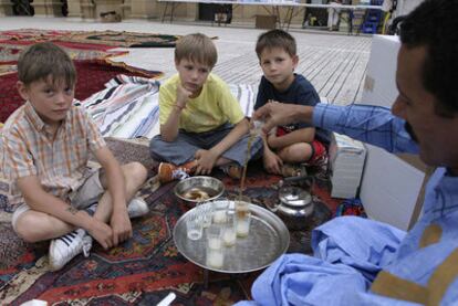 Tres menores de Chernóbil observan cómo se prepara el te en una fiesta de acogida a los niños saharauis y de la antigua URSS.