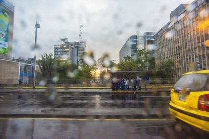 Usuarios del transporte público bajo la lluvia. Aguaceros y atascos forman parte del paisaje cotidiano de Bogotá.