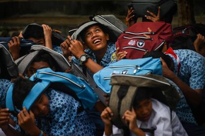 Estudiantes se cubren la cabeza durante un simulacro de terremoto y tsunami en su escuela en Banda Aceh en Sumatra.