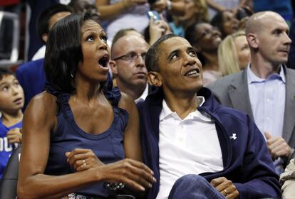 El presidente de EE UU y su mujer reaccionan ante una acción del partido de baloncesto.