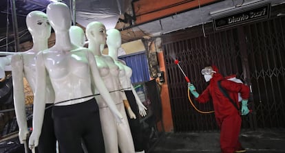 Un bombero rocía desinfectante en maniquíes como medida sanitaria contra el brote de coronavirus, en el mercado textil de Tanah Abang en Yakarta (Indonesia).