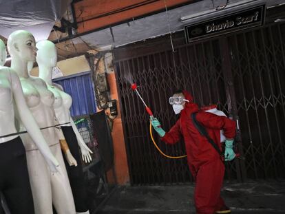 Un bombero rocía desinfectante en maniquíes como medida sanitaria contra el brote de coronavirus, en el mercado textil de Tanah Abang en Yakarta (Indonesia).