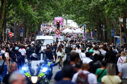 Centenares de espectadores caminan por el perímetro de seguridad momentos horas antes del comienzo de la ceremonia de inauguración, este viernes en París. 