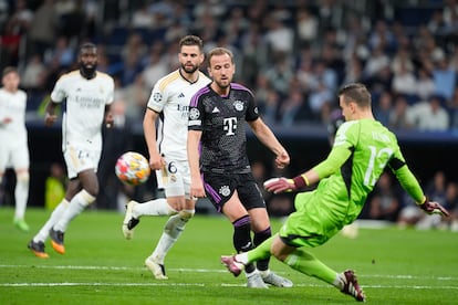 O jogador do Real Madrid, Lunin, limpa a bola para o jogador do Bayern, Harry Kane.