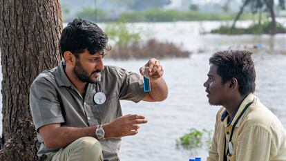 Arun Krishnamurthy y un voluntario de su organización toman una muestra de agua en el lago Kollappancheri para analizar su calidad.