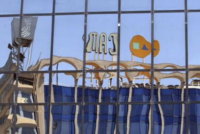 CAM's Alicante headquarters, reflected on the glass of the building opposite.