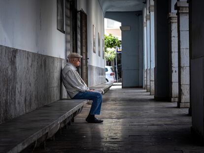 Una persona mayor descansa en un banco de una población valenciana.