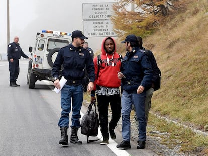 Un hombre es escoltado por la policía italiana en Claviere, localidad fronteriza entre Francia e Italia, el 22 de octubre de 2018.