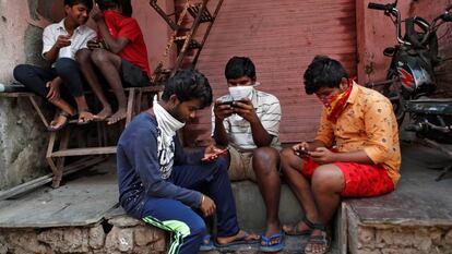 Um grupo de jovens checa seus celulares em Bombaim.