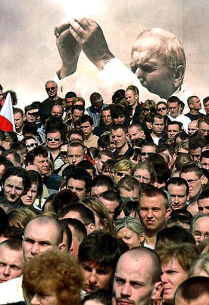 Miles de personas siguen el funeral a través de pantallas gigantes en la plaza Pilsudski, en Varsovia.