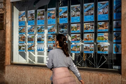 Una joven pasa junto a una inmobiliaria en Santander.