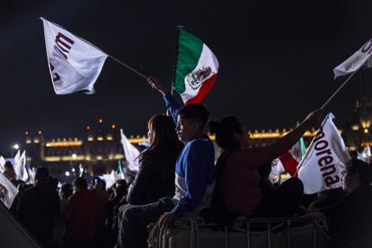 Seguidores de López Obrador sostienen banderas mexicanas y de Morena.