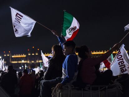 Seguidores de López Obrador sostienen banderas mexicanas y de Morena.