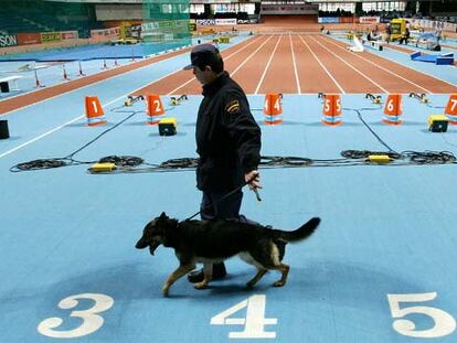 Un policía examina con un perro las pistas del Palacio de los Deportes de Madrid.