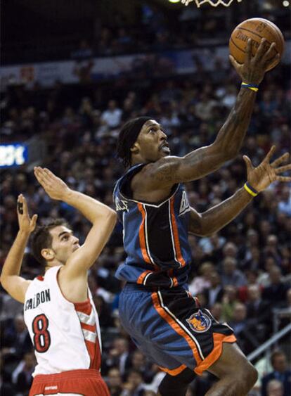 El jugador de los Bobcats Gerald Wallace supera a José Calderón de los Toronto Raptors.