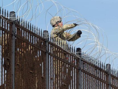 Soldados estadounidenses instalan alambrado en la valla fronteriza con México. 