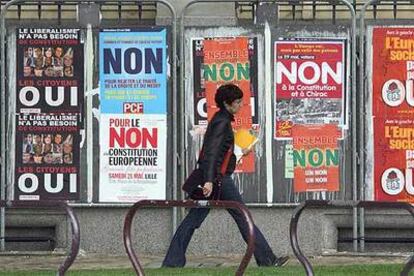 Una mujer pasea ante carteles a favor y en contra de la Constitución europea, ayer en la ciudad de Lille.