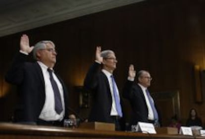 El consejero delegado de Apple Tim Cook (C) , el director financiero de la empresa Peter Oppenheimer (izquierda) y el responsable de operaciones fiscales Philip Bullock juran ayer en su testimonio ante el Senado de Estados Unidos.