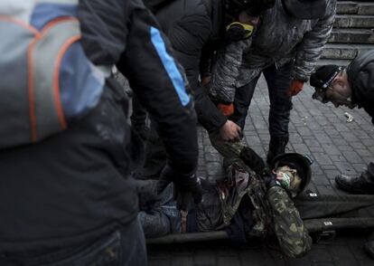 Activistas de la oposición trasladan el cuerpo sin vida de un manifestante durante los enfrentamientos contra la policía en la Plaza de la Independencia en Kiev, 20 de febrero de 2104.