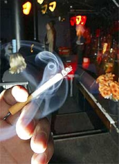 Un joven fuma a las puertas de un <i>pub</i> en Oslo pasada la medianoche, cuando entró en vigor la norma.
