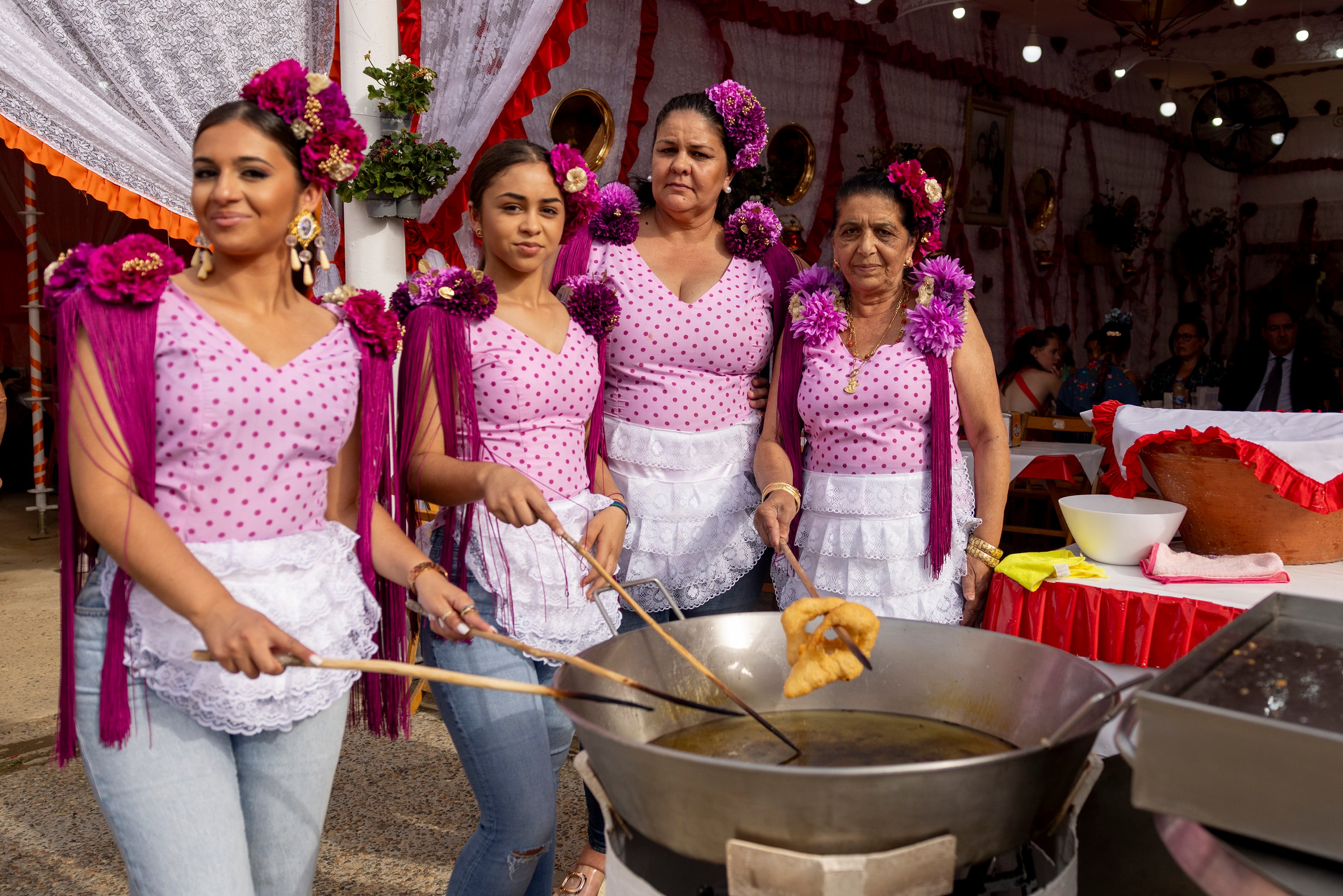 Adela Manzano Rivera junto a su nuera y nietas en el puesto de buñuelos Adela y Luis en la Feria de Sevilla.
