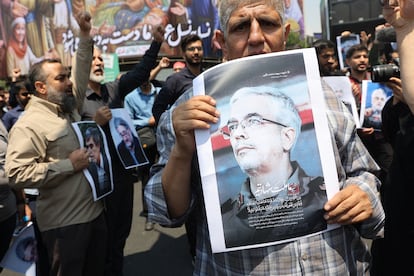 Un iraní sostiene un retrato del Jefe del Estado Mayor de las Fuerzas Armadas iraníes, el general Mohamad Hosein Baqerí, muerto en un ataque aéreo israelí, durante una protesta en Teherán.