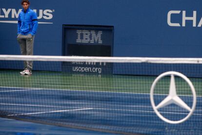 Nadal observes the soaked court after his match against Müller was suspended.