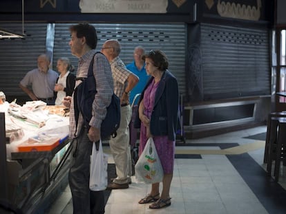 Varias personas compran en un mercado de Madrid.