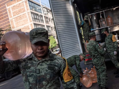 Elementos del Ejército mexicano cargan garrafones de agua para apoyar a los vecinos de la delegación Benito Juárez.