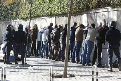 Agentes de policía retienen a un grupo de jóvenes tras los disturbios que provocaron en la calle de Serrano.