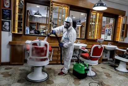 Un trabajador desinfecta una barbería en Roma este viernes.