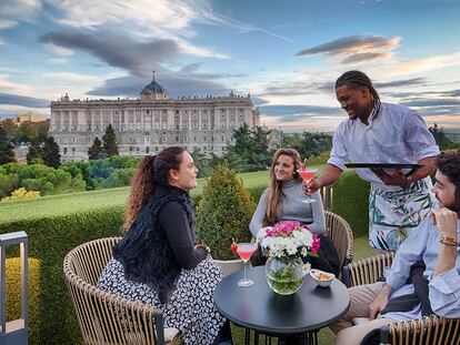 Un grupo de amigos disfruta de las vistas del Palacio Real en la la terraza de los Apartosuites Jardines de Sabatini, en Madrid.