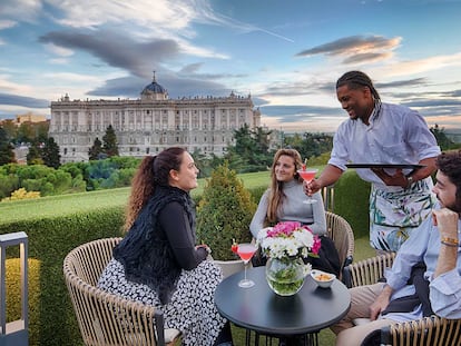 Un grupo de amigos disfruta de las vistas del Palacio Real en la la terraza de los Apartosuites Jardines de Sabatini, en Madrid.